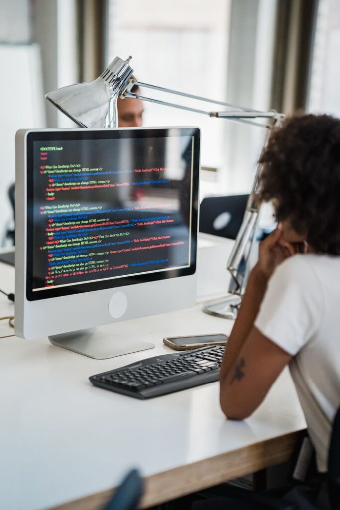 Mastering the First Impression: Your intriguing post title goes here A female professional focused on coding at her office desk with a desktop computer.