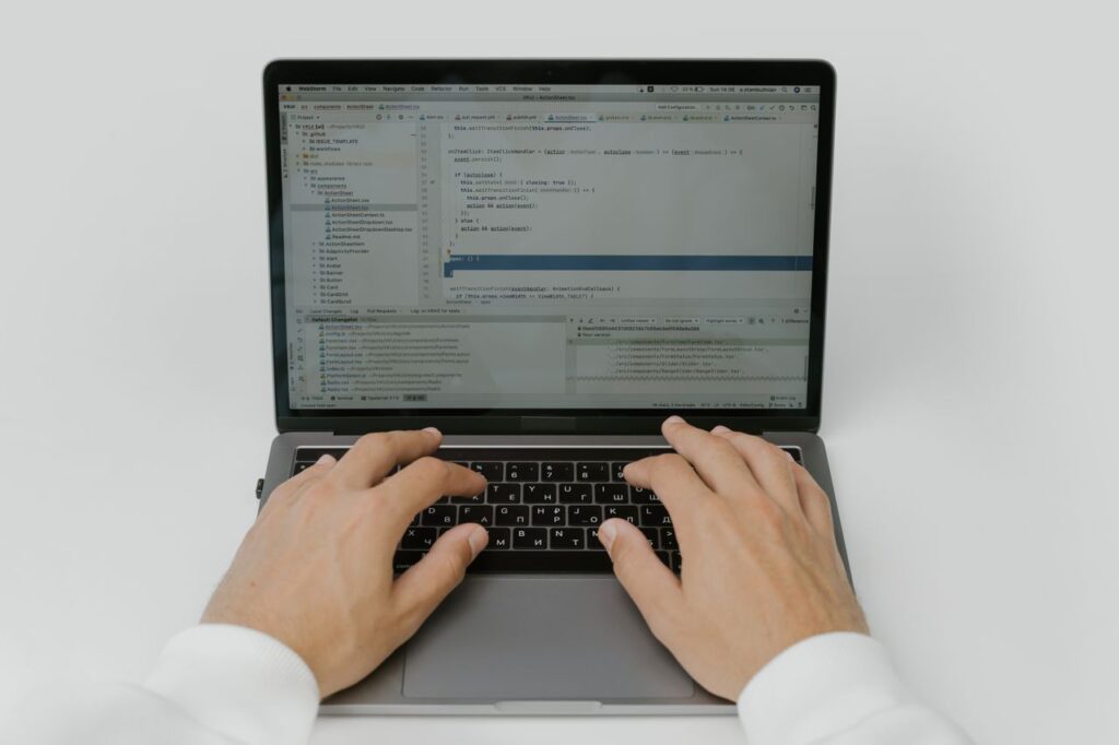 The Art of Drawing Readers In: Your attractive post title goes here Close-up of hands coding on a laptop, showcasing software development in action.